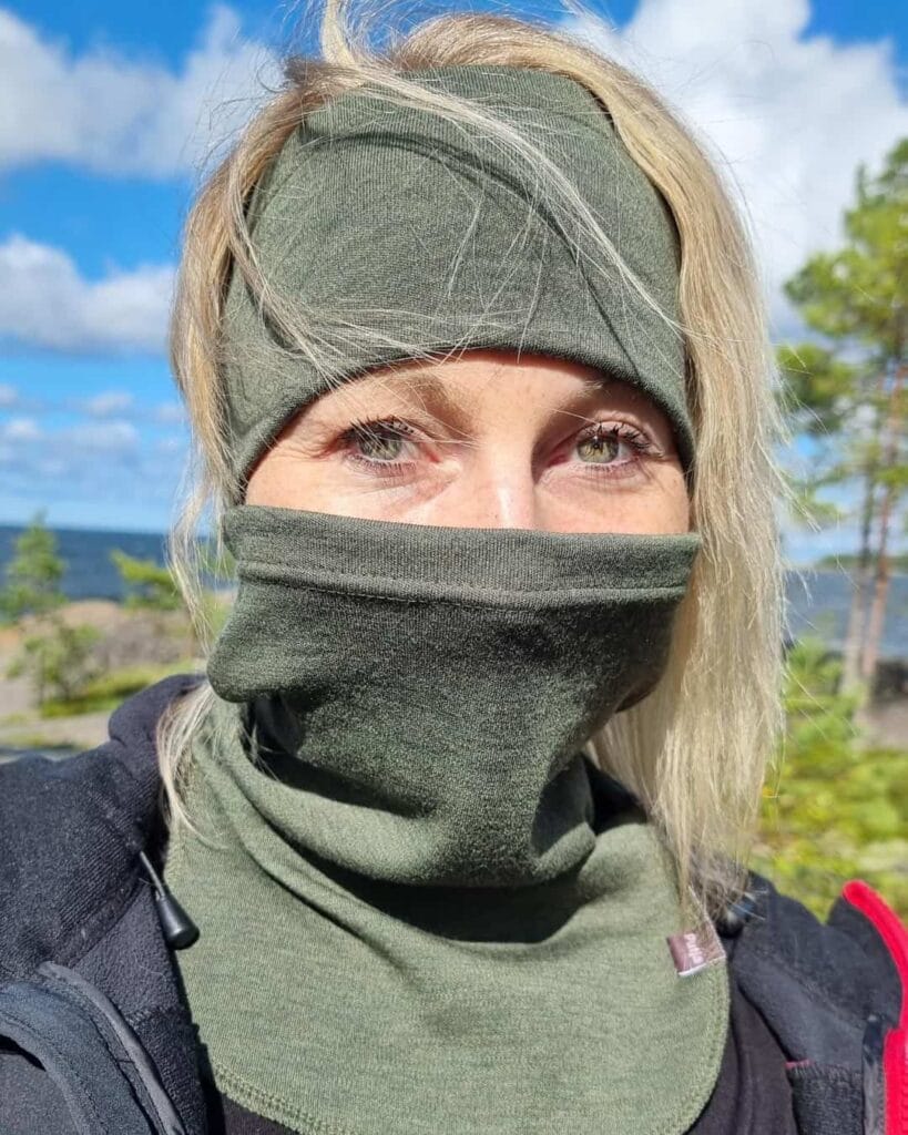 Naisten metsänvihreä merinovillapanta ja -tuubikauluri, naisen päällä, tuubikauluri kasvoille vedettynä.