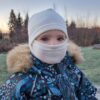 Lasten luonnonvalkoinen merinovilla kypärähuppu (balaclava) pienen lapsen päässä, kasvot suojattuna.