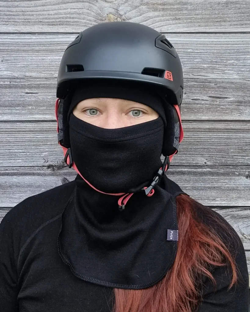 Schwarze Merinowolle Sturmhaube für Erwachsene unter einem Skihelm.