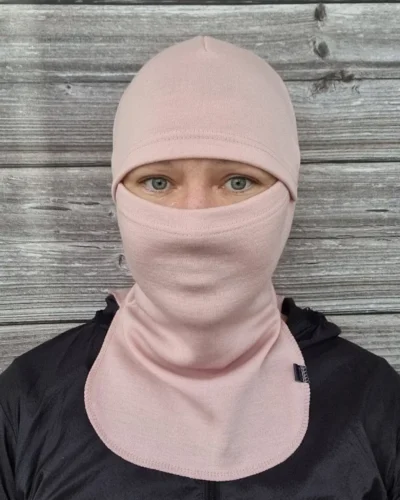 Aikuisten vaaleanpunainen merinovilla kypärähuppu (balaclava), naisen päässä edestä.