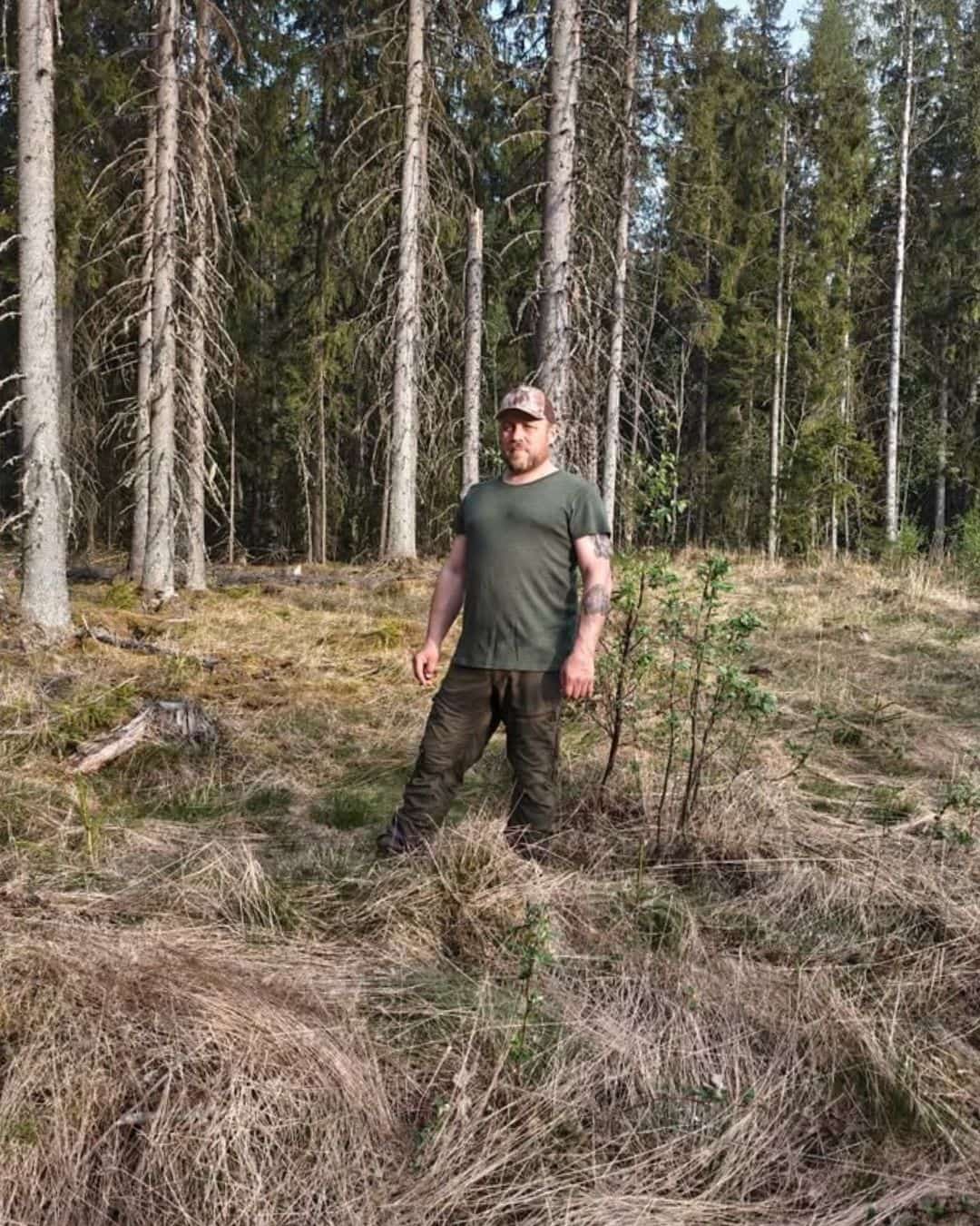 Miesten L-kokoinen metsänvihreä merinovilla t-paita, metsässä pitkän miehen päällä kuvattuna.