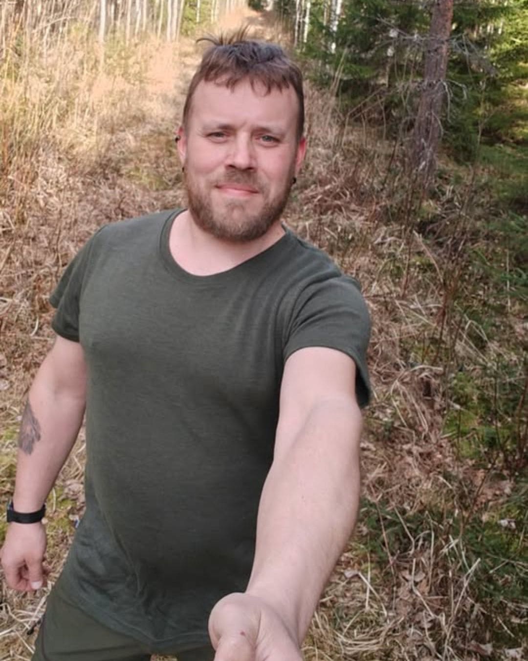 Miesten L-kokoinen metsänvihreä merinovilla t-paita, pitkän miehen päällä läheltä kuvattuna.
