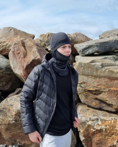 Lasten tummanharmaa merinovilla kypärämyssy (balaclava). Nuoren miehen päässä etuviistosta kuvattuna.