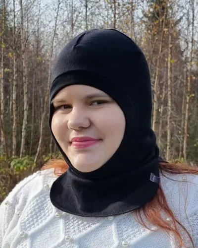 Aikuisten musta merinovilla kypärämyssy. Lähikuva naisen päässä.