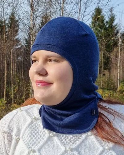 Aikuisten farkunsininen merinovilla kypärämyssy. Lähikuva naisen päässä.