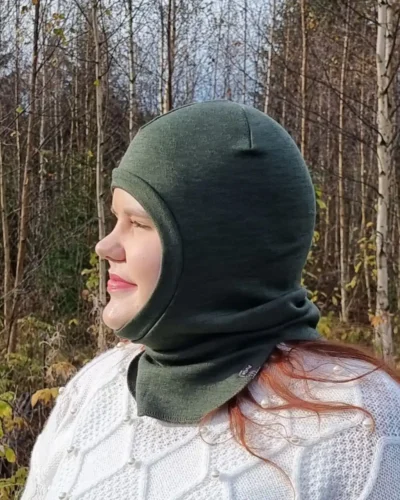 Aikuisten metsänvihreä merinovilla kypärämyssy. Lähikuva naisen päässä, sivultapäin.