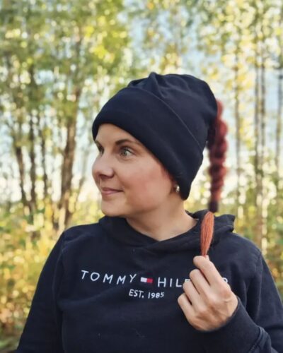 Naisten musta merinovilla ponnaripipo lettipäisellä naisella. Lähikuva edestä.